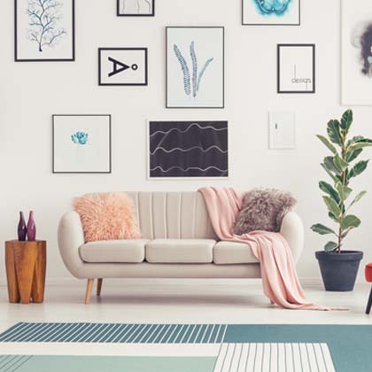 White couch with furry pillows and pink blanket